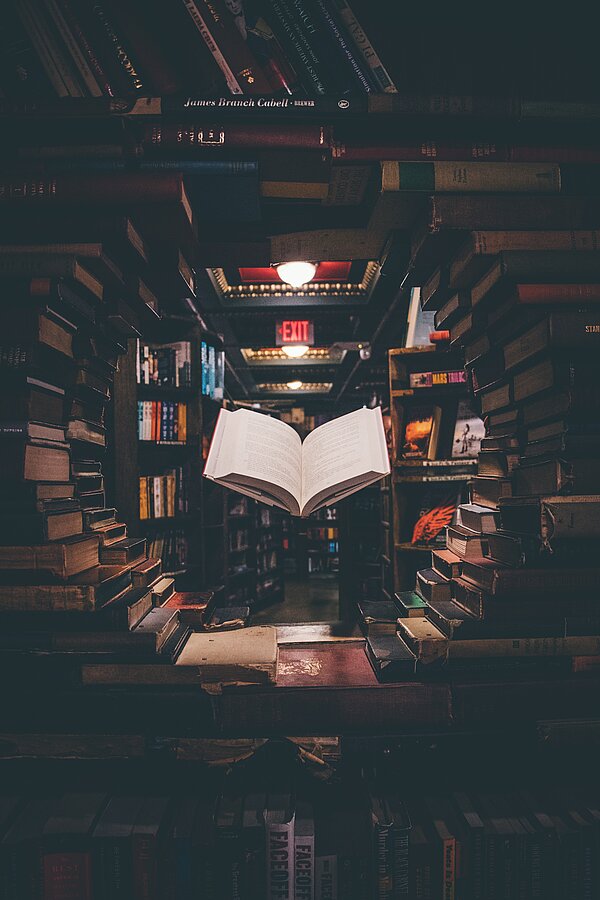 En uppslagen bok leviterar i luften. Foto: Jaredd Craig, Unsplash.