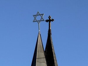 Toppen av två kyrktorn som visar Davidsstjärnan och ett kors.